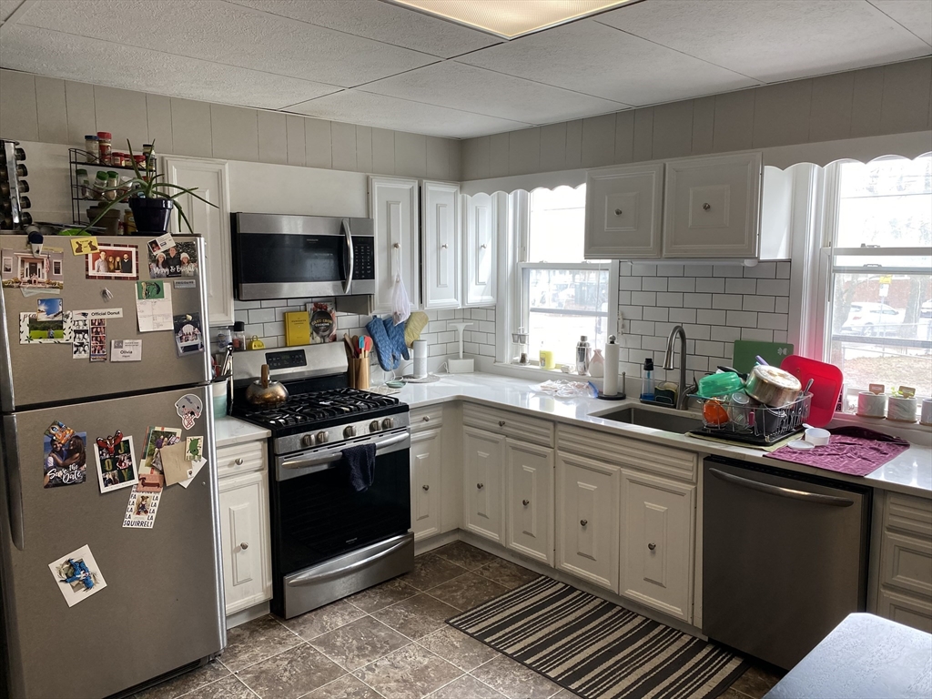 a kitchen with stainless steel appliances a sink stove and microwave