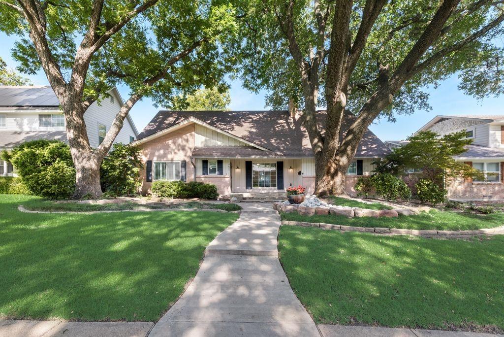 a front view of a house with yard and green space