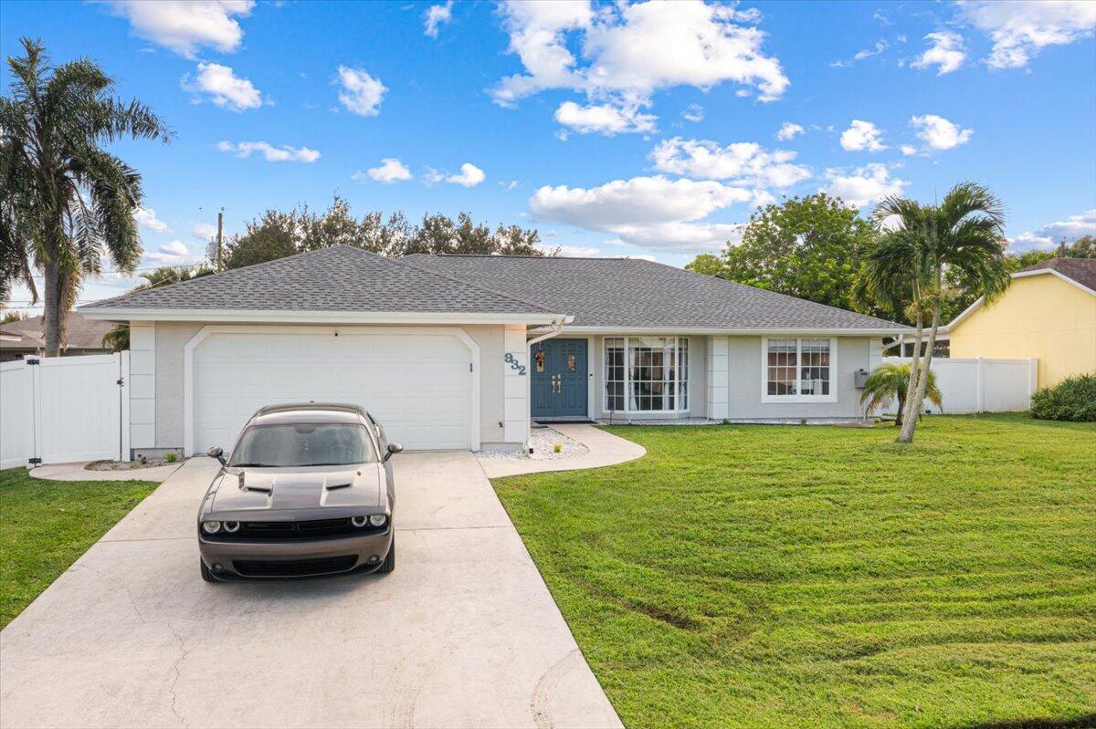 a car parked in front of a house with a yard