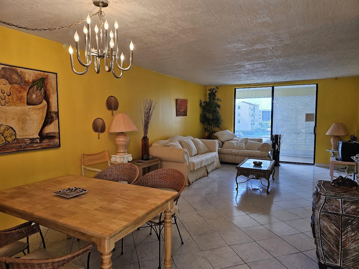 a living room with patio furniture and a chandelier