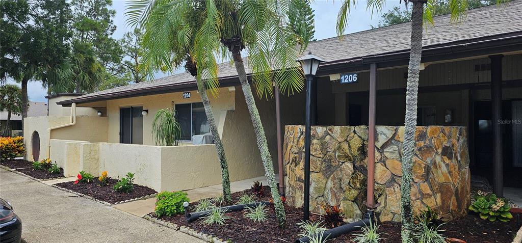 a view of a house with a yard and potted plants