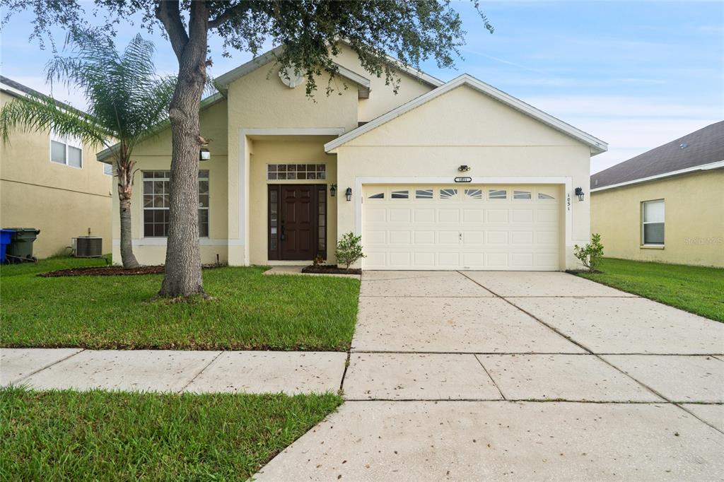 a front view of a house with a yard and garage