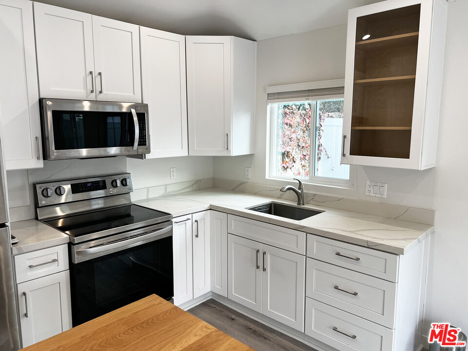 a kitchen with white cabinets appliances and sink