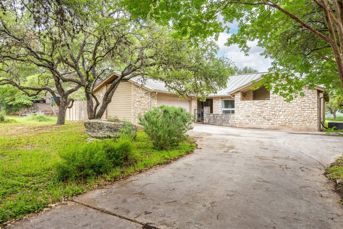 a front view of a house with a yard and trees