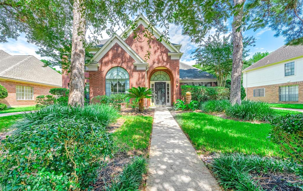 a front view of a house with yard and green space