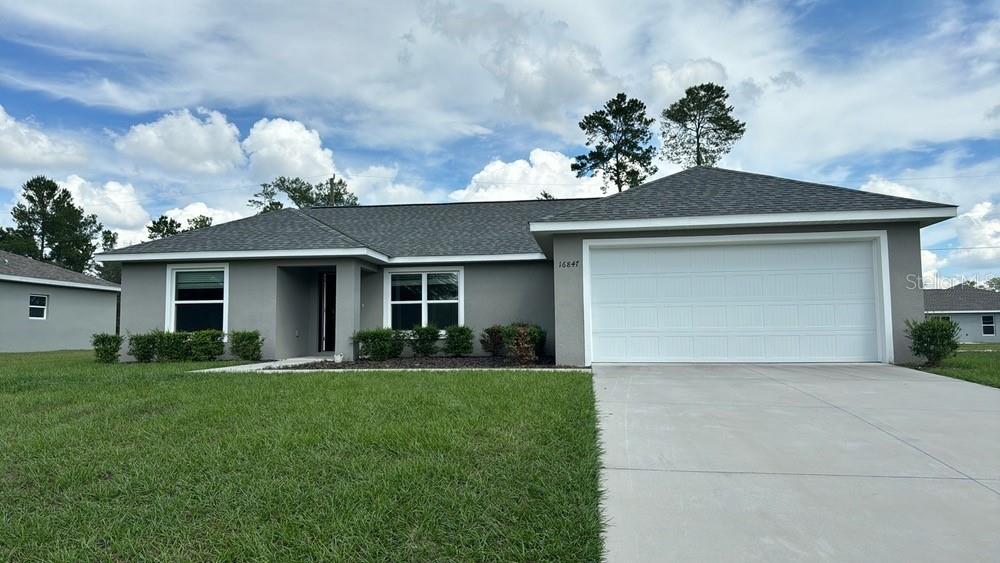 a front view of a house with a yard and garage