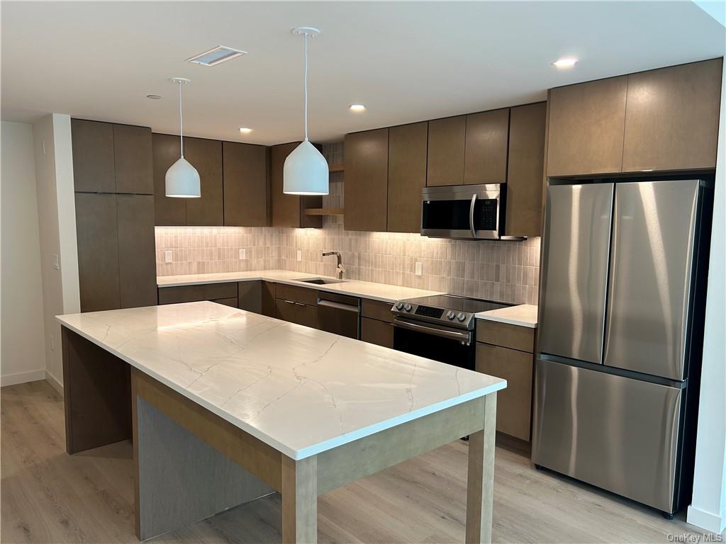 a kitchen with a refrigerator a sink and a microwave