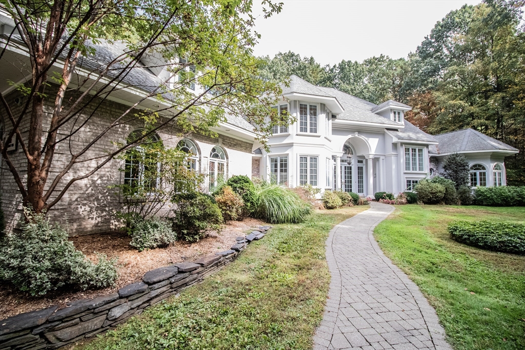 a front view of a house with a yard and shrubs