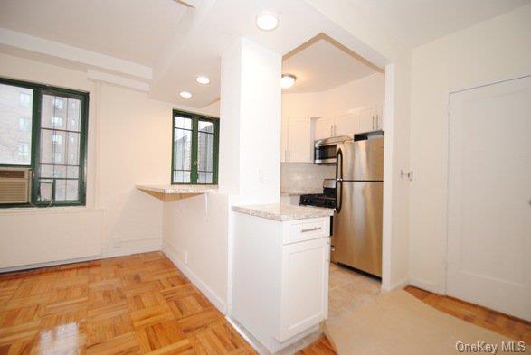 a view of a kitchen with refrigerator and wooden floor