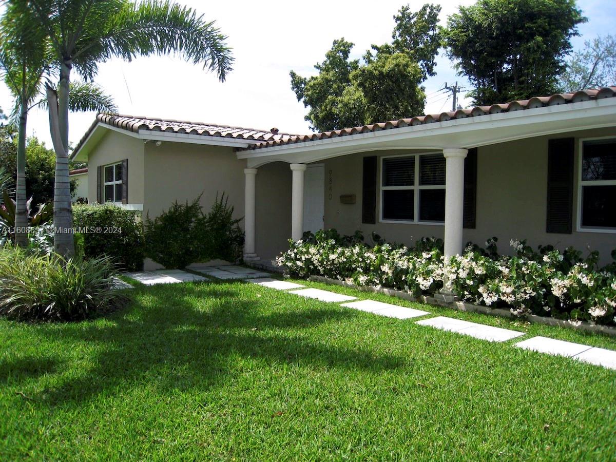 a front view of a house with a garden