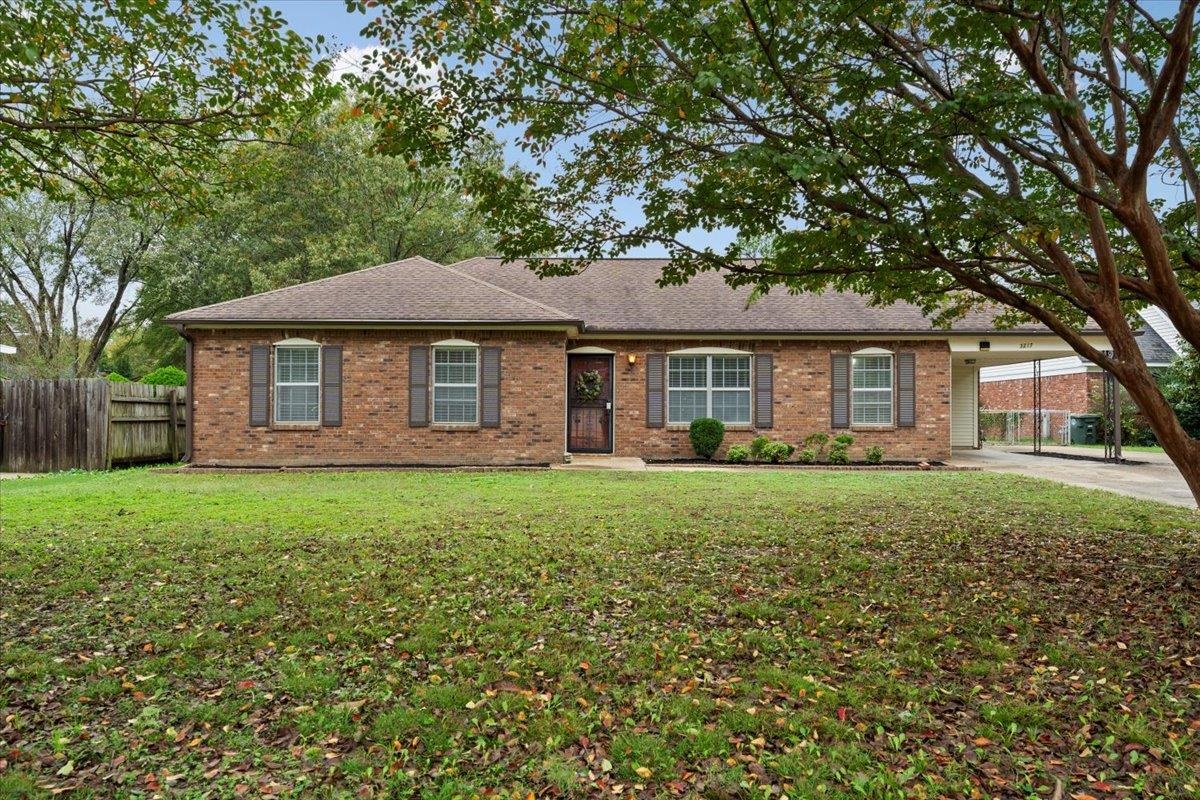 Single story home featuring a front yard and a carport