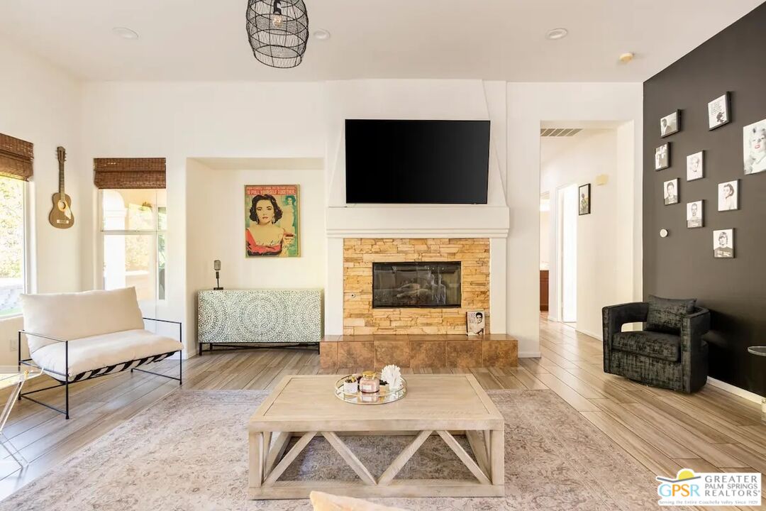 a living room with furniture a flat screen tv and a fireplace