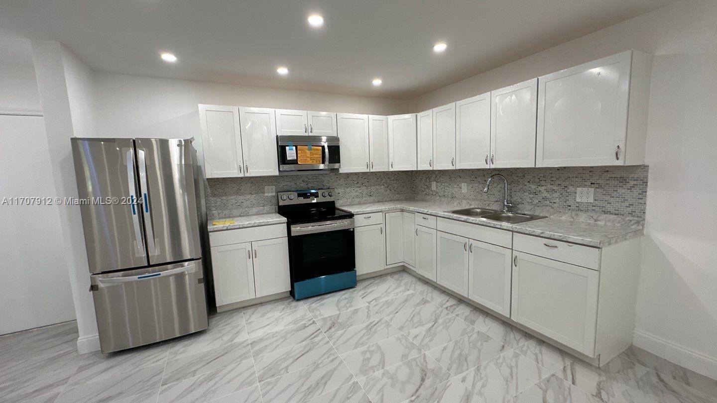 a kitchen with stainless steel appliances a refrigerator sink and microwave