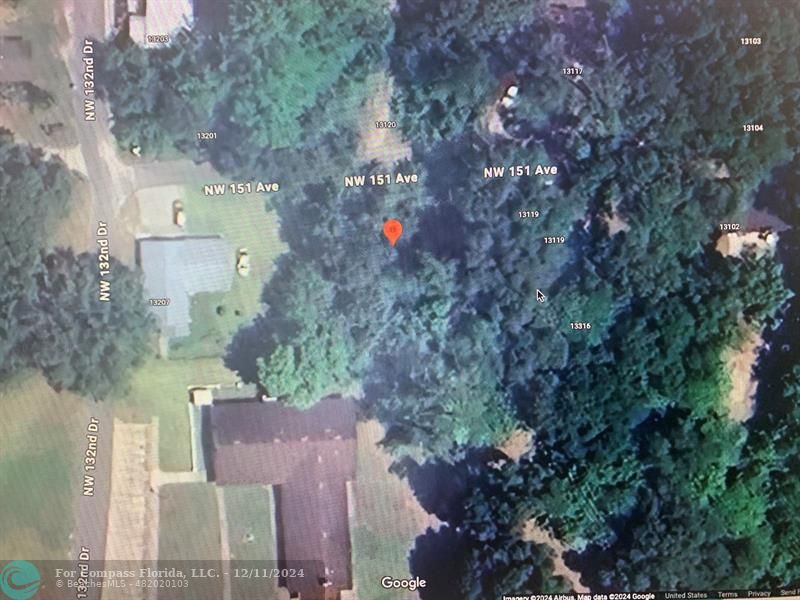 an aerial view of a house with a yard and large tree