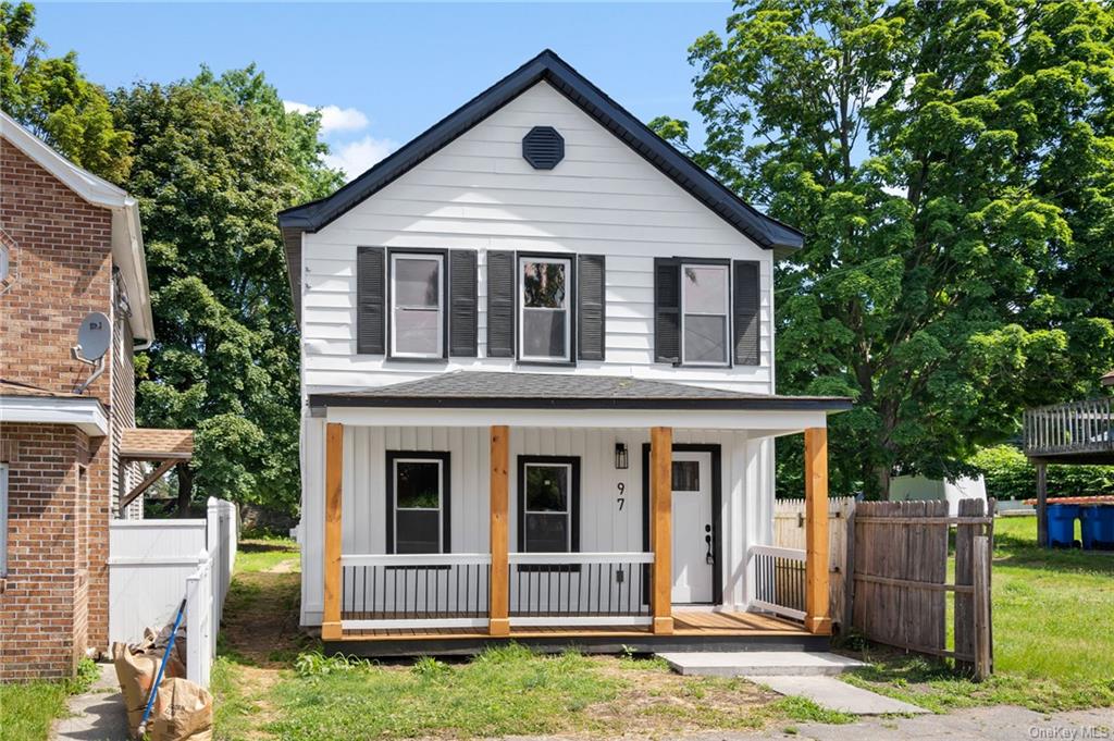 View of front of house with a porch and a front yard