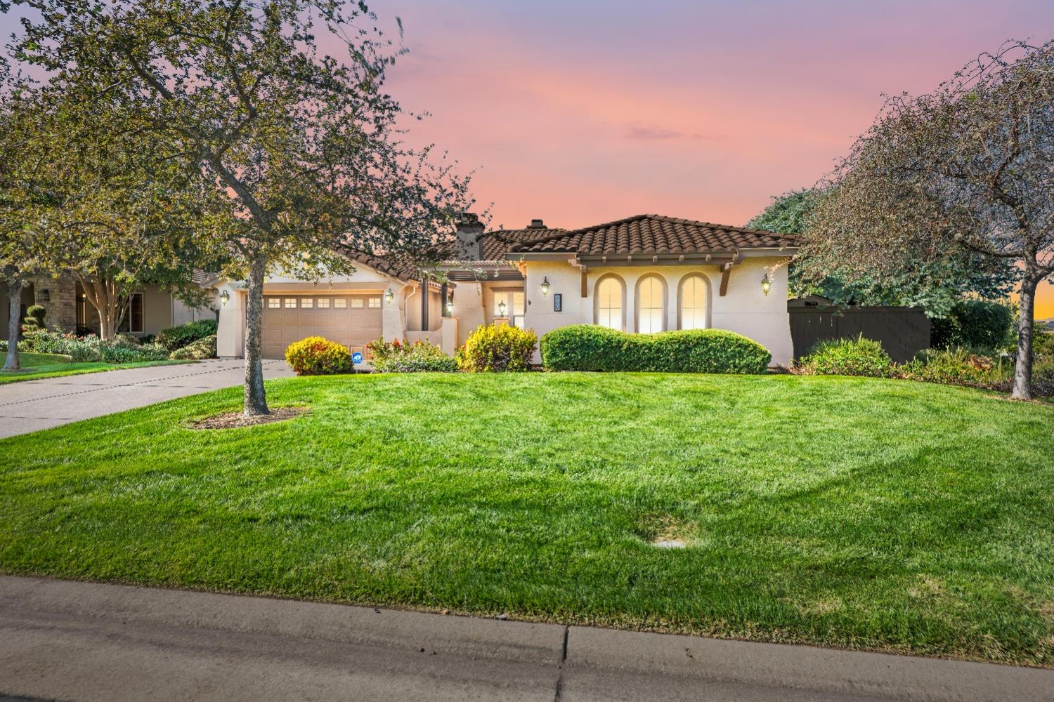 a front view of a house with a yard and trees