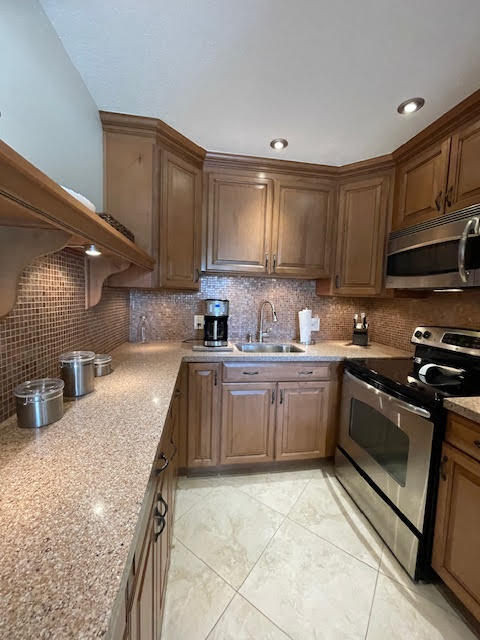 a kitchen with a sink stove top oven and cabinets