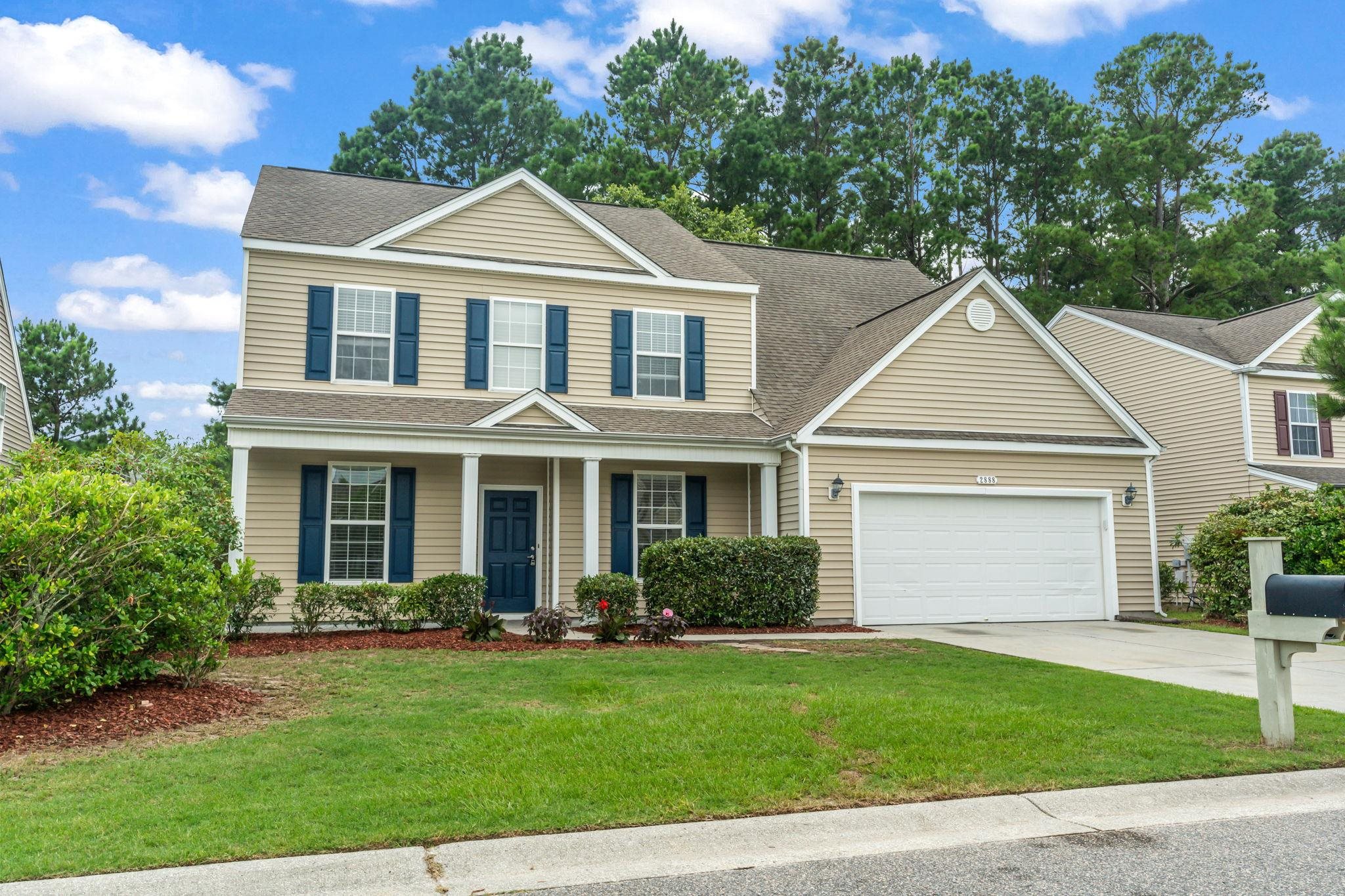 View of front of house with a garage and a front y