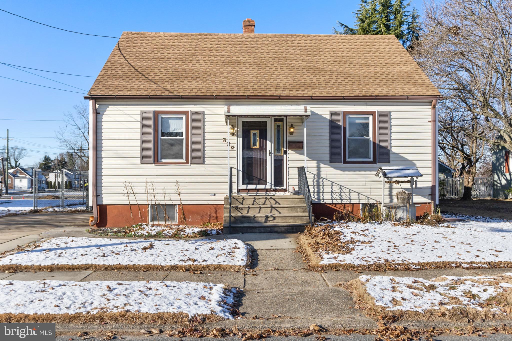 a front view of a house with a yard covered in snow