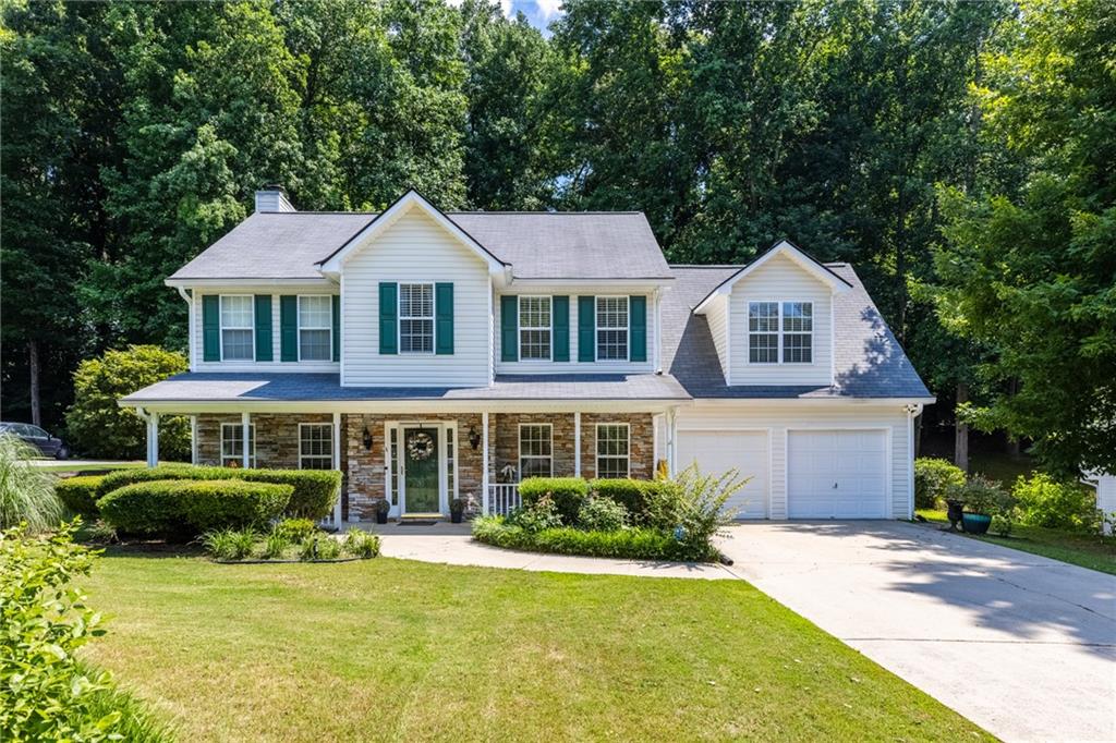 a front view of a house with a yard and green space