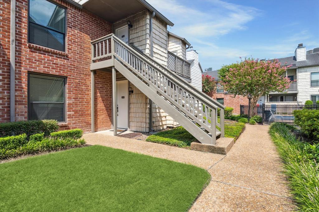 a front view of a house with a yard and potted plants