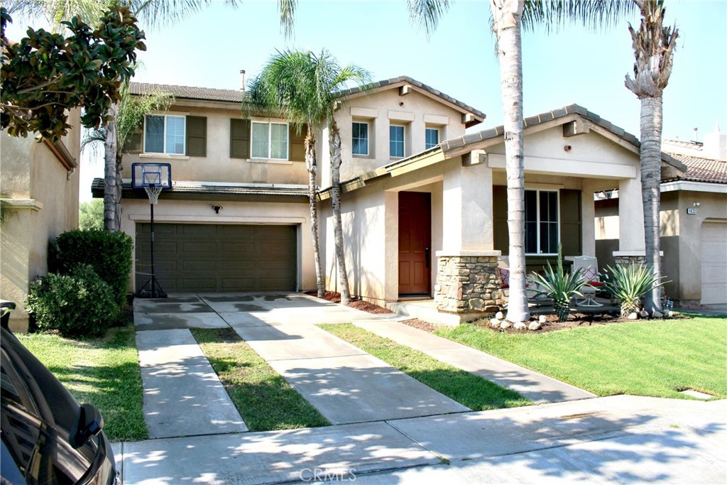 a front view of a house with a yard and potted plants