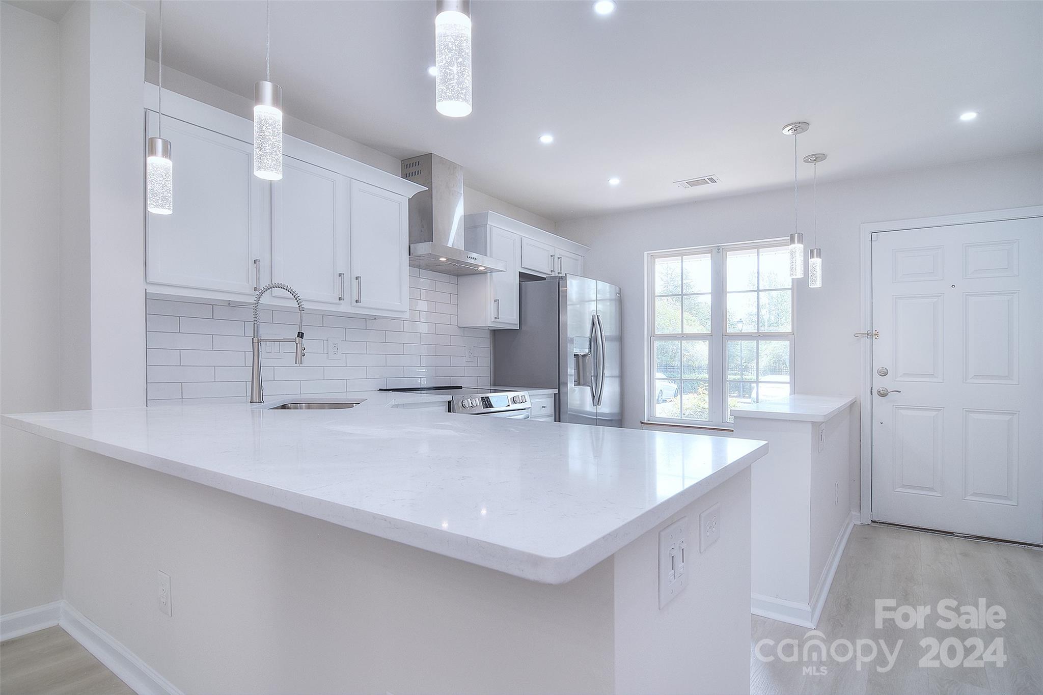 a large kitchen with kitchen island a sink appliances and a counter top space