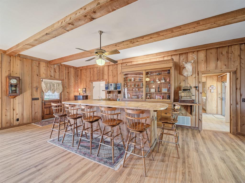 a dining area with chandelier fan and wooden floor