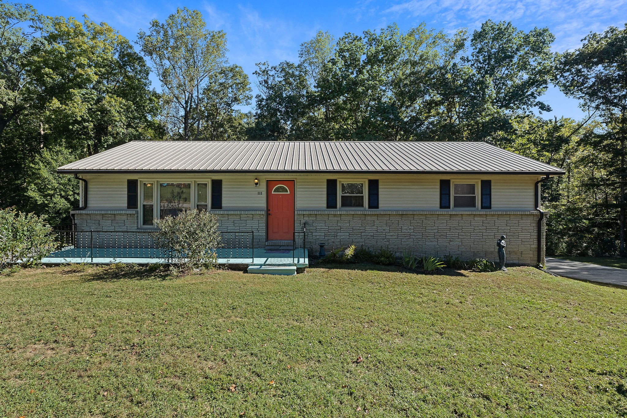 a front view of a house with yard and trees