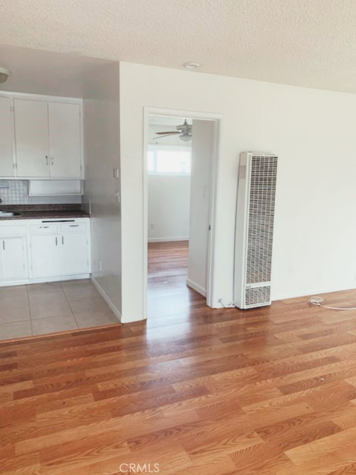 a view of a kitchen with wooden floor and cabinets