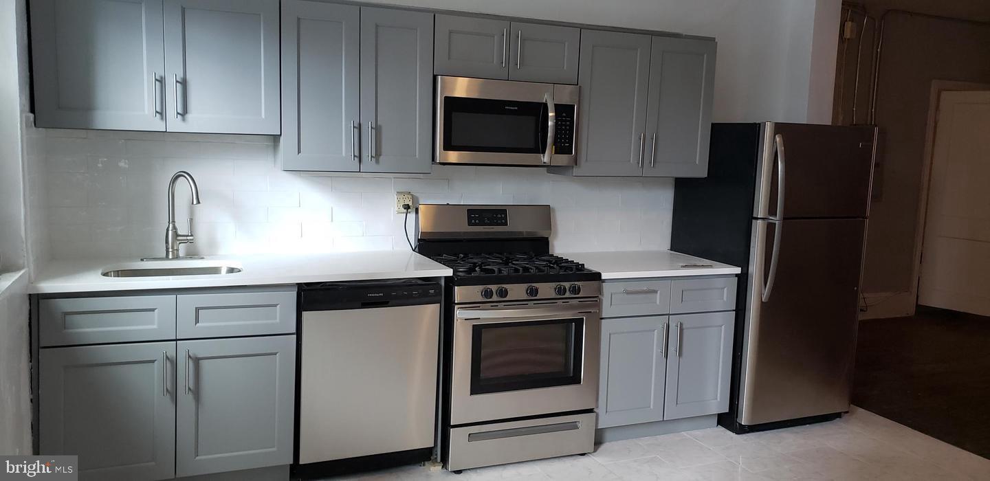 a kitchen with appliances a refrigerator and cabinets