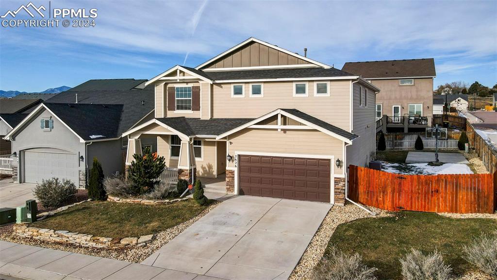 View of front facade featuring a front yard and a garage