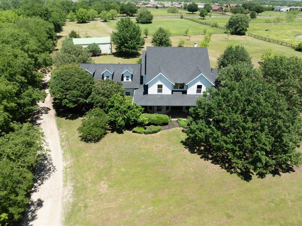 an aerial view of a house with a yard and lake view