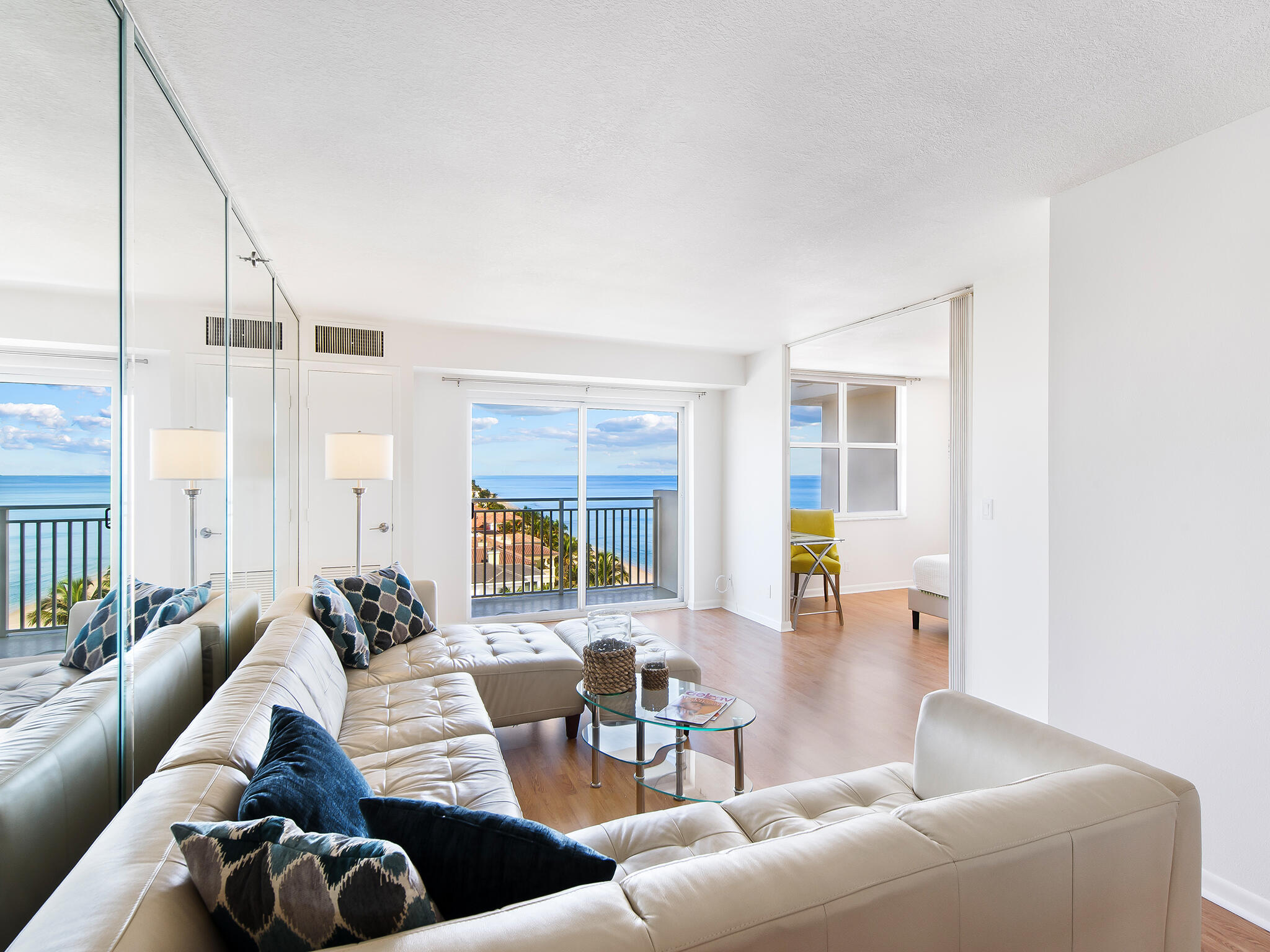 a living room with furniture wooden floor and floor to ceiling window