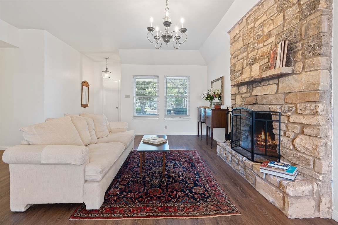 a living room with furniture a fireplace and a chandelier