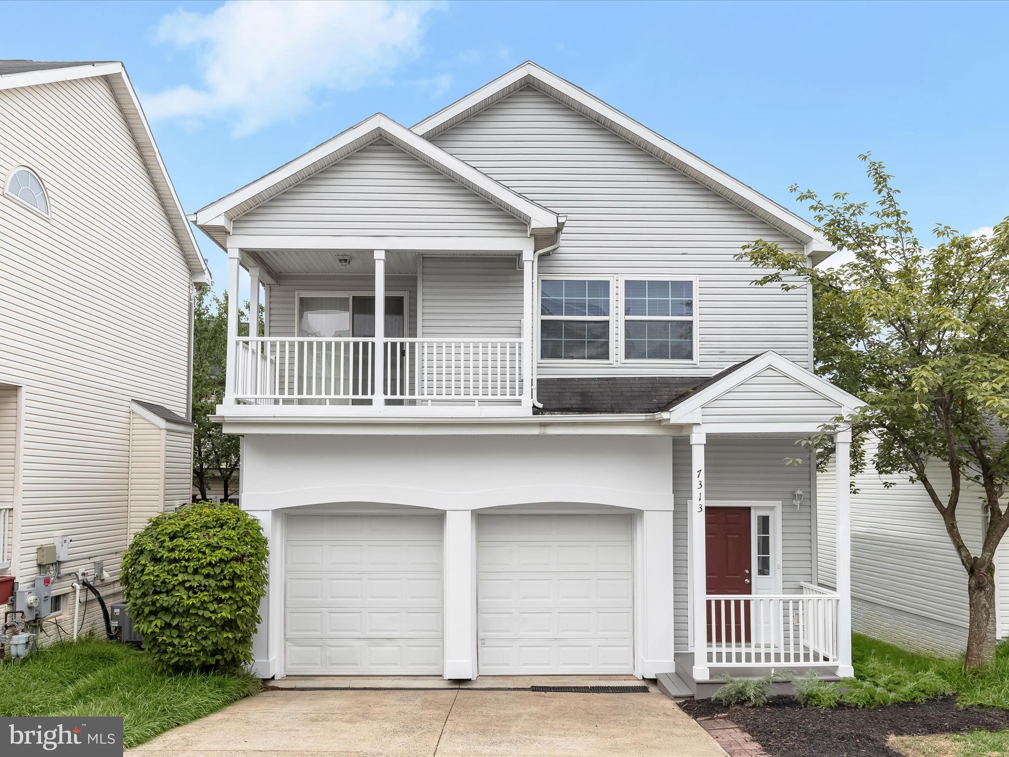 a front view of a house with a garage and balcony