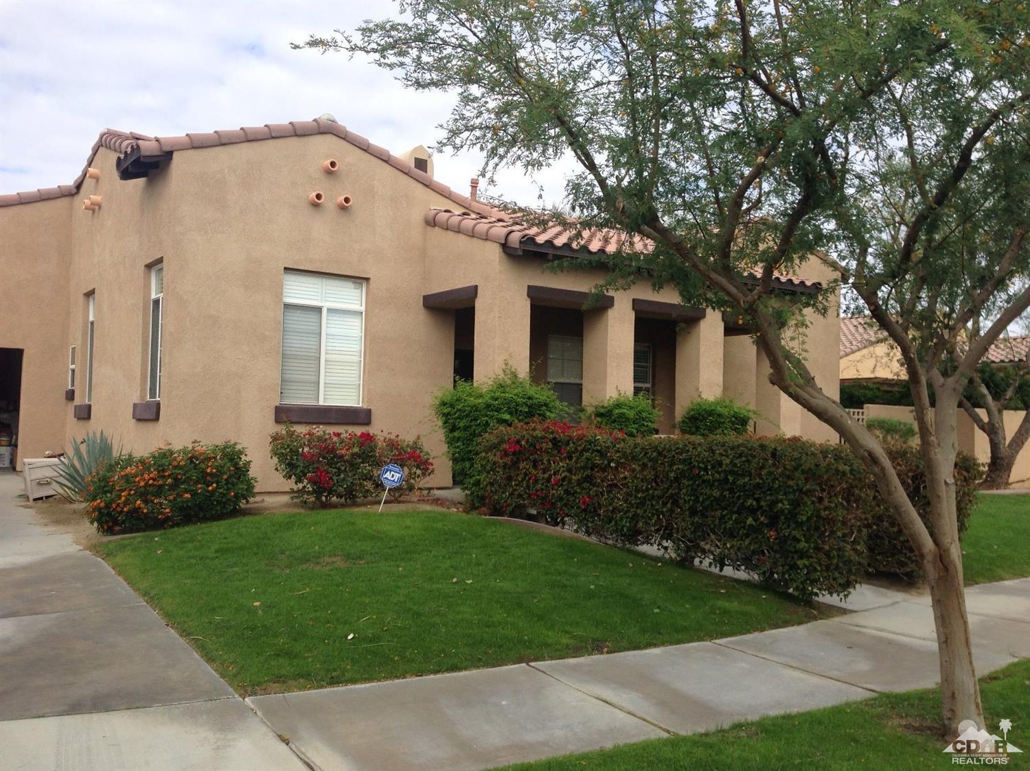 a front view of a house with a garden and plants