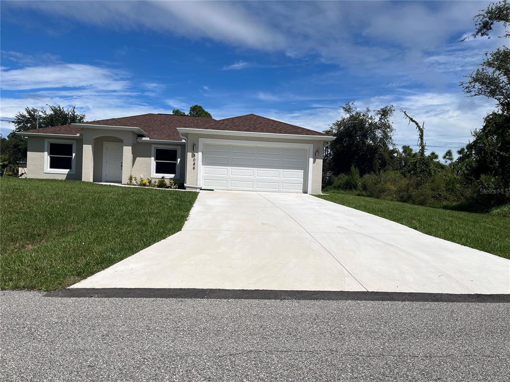 a front view of a house with a yard and trees