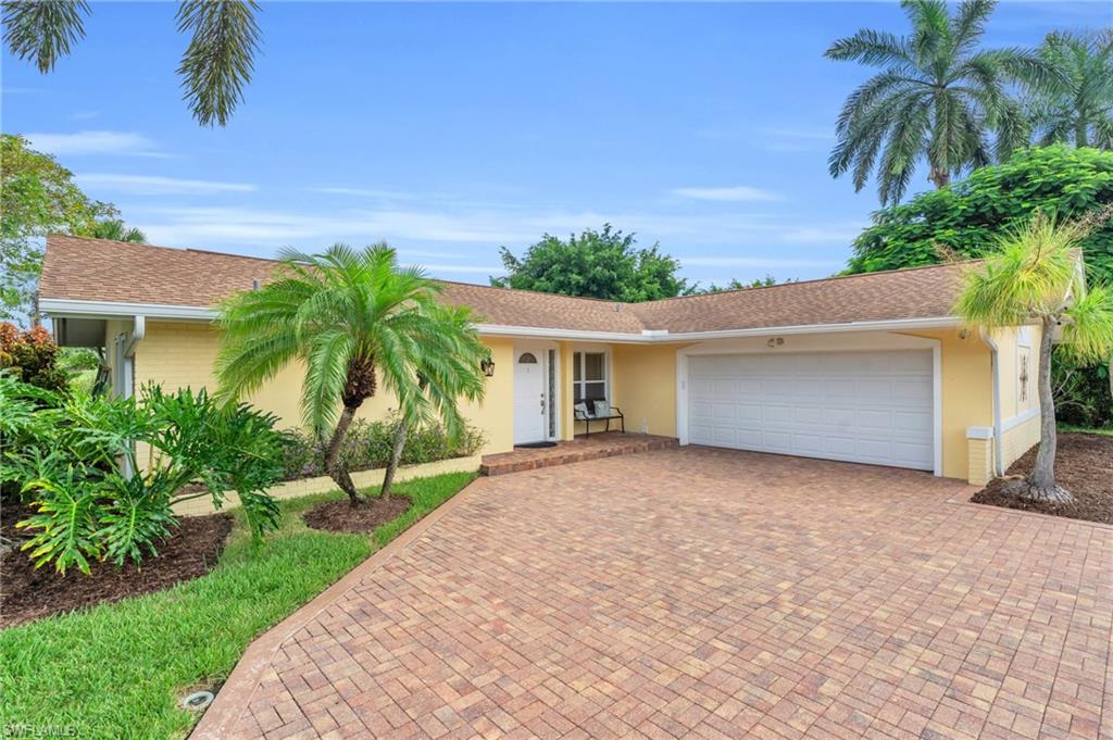 The front of the home and the circular driveway with a 2 car garage