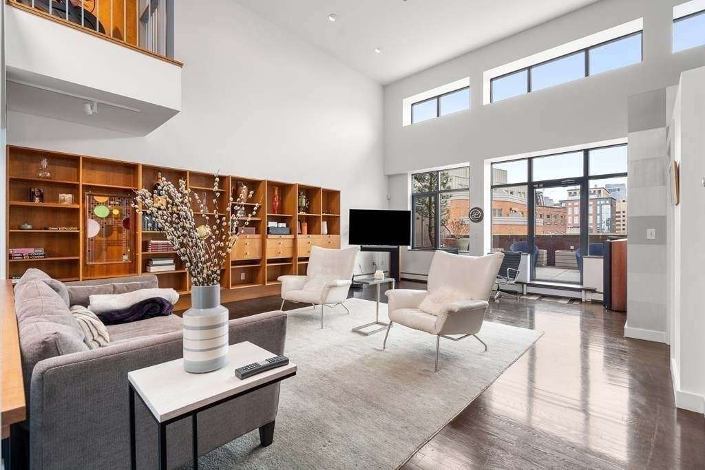 a living room with furniture a rug and a floor to ceiling window