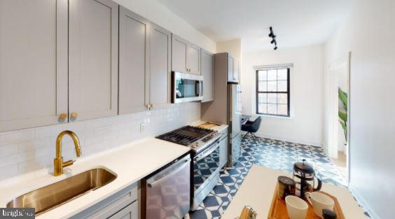 a kitchen with granite countertop a sink a stove and cabinets