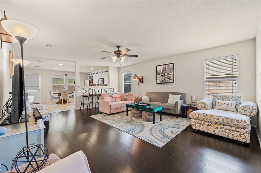 a living room with furniture wooden floor and a large window