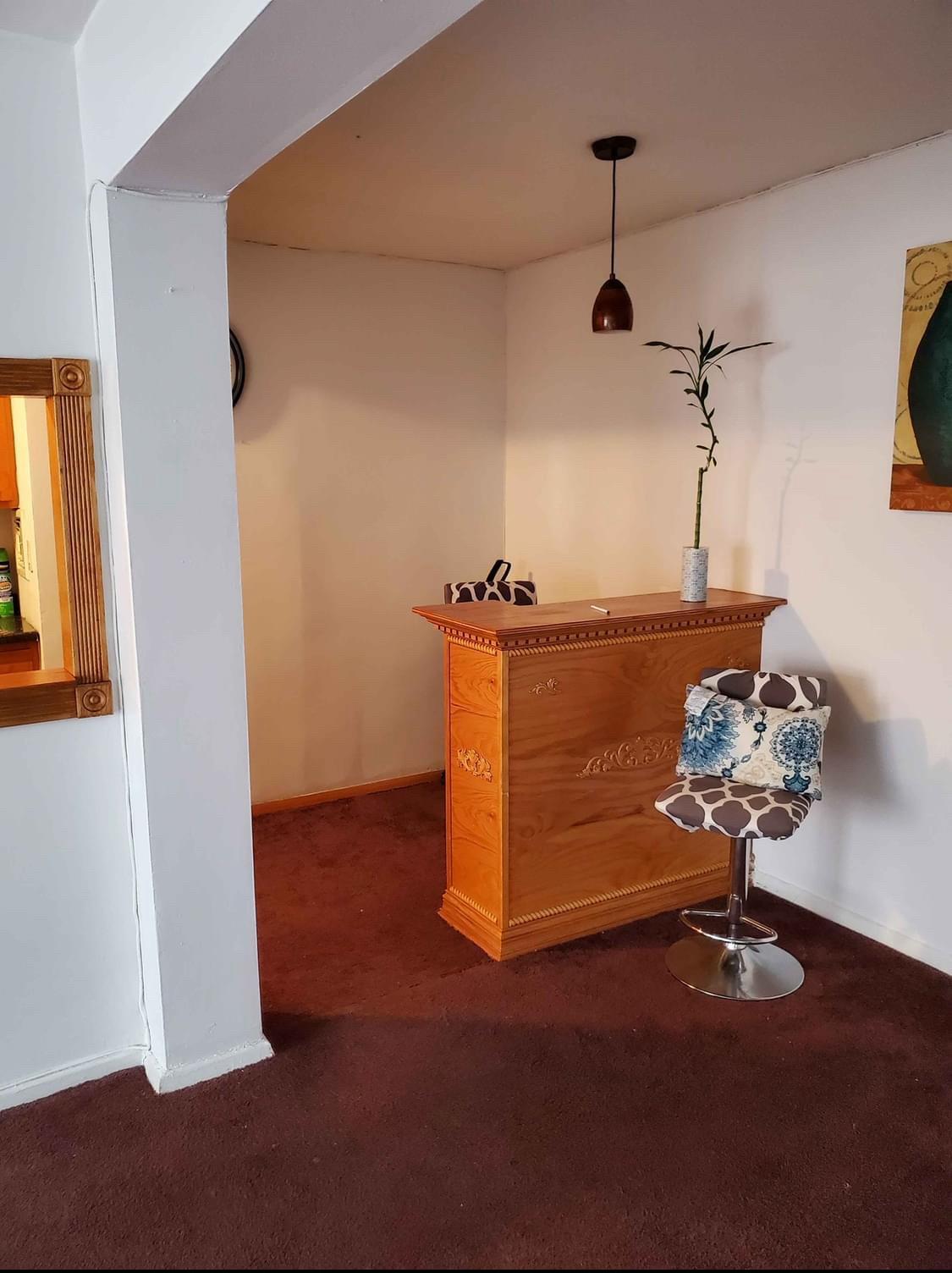 Bar with dark carpet and hanging light fixtures