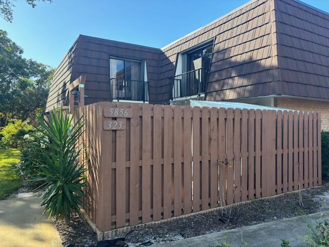 a view of a house with a wooden fence