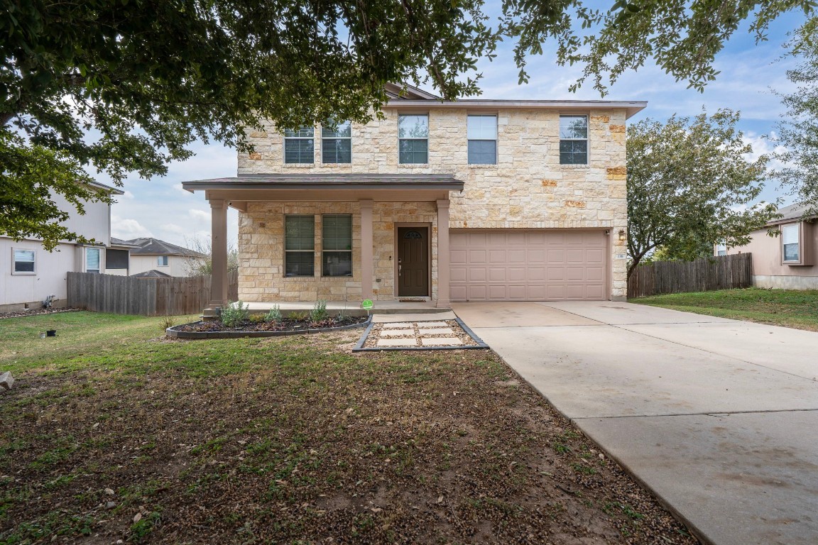 a front view of a house with a yard and garage