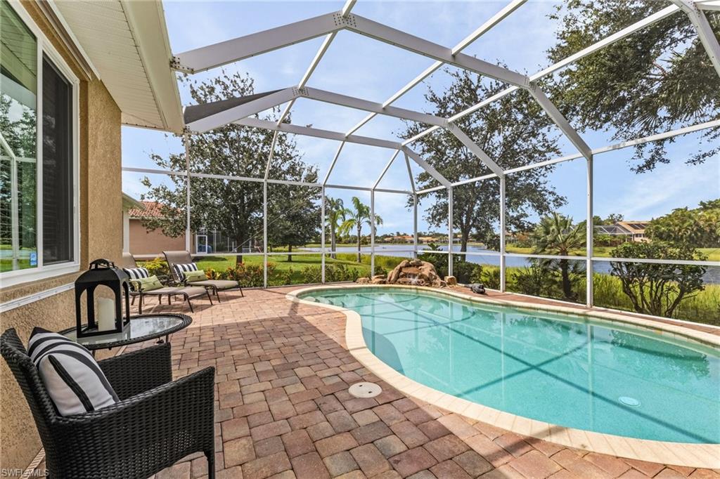 a view of a swimming pool with a couches chairs and wooden floor