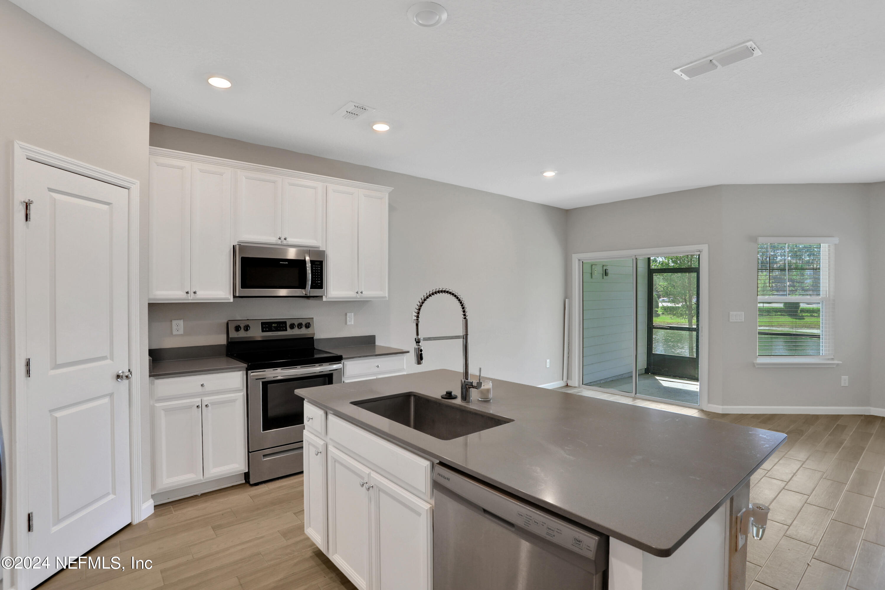 a kitchen with stainless steel appliances granite countertop a sink a stove and a refrigerator