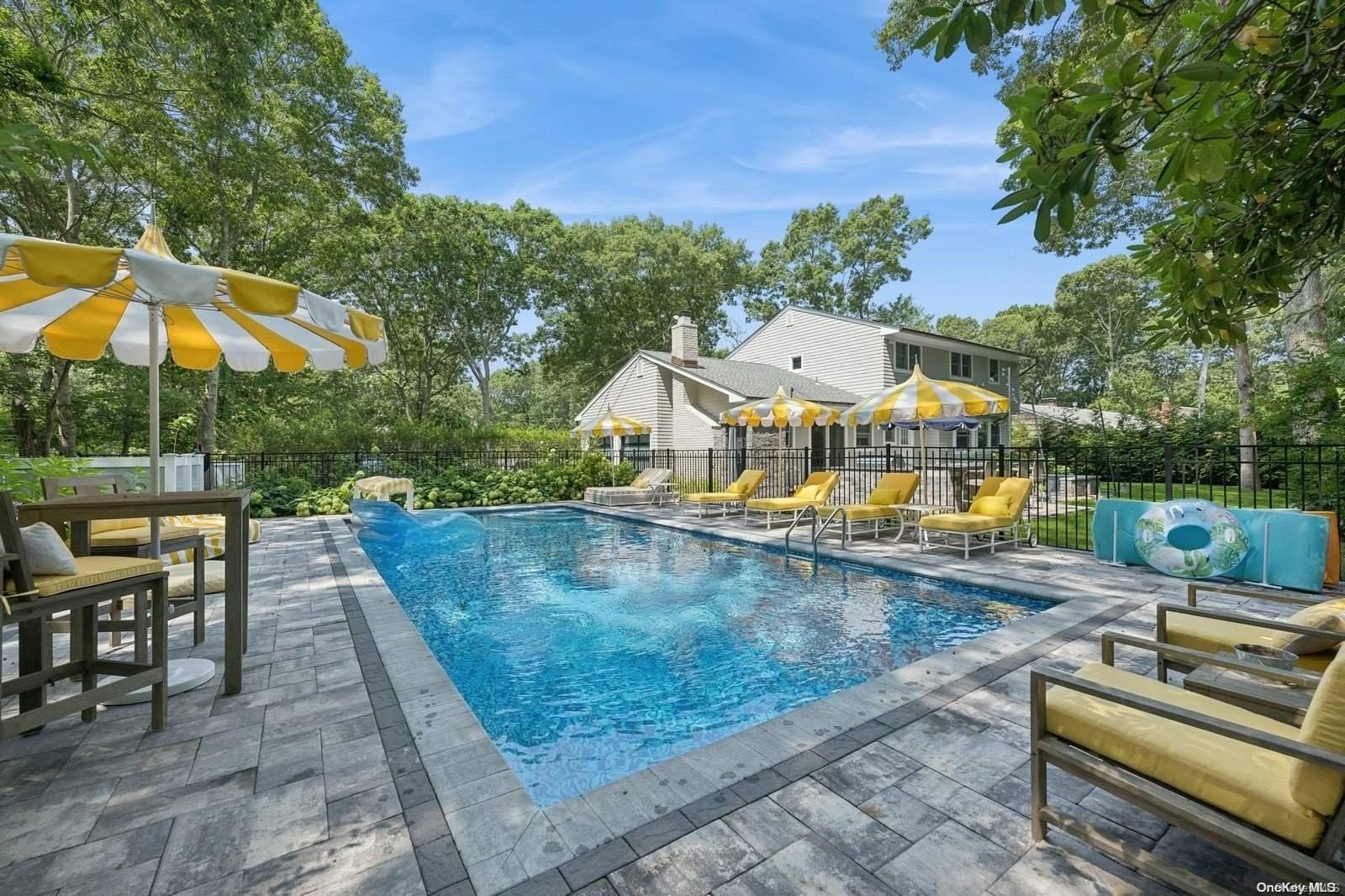 an outdoor sitting area with furniture and umbrella