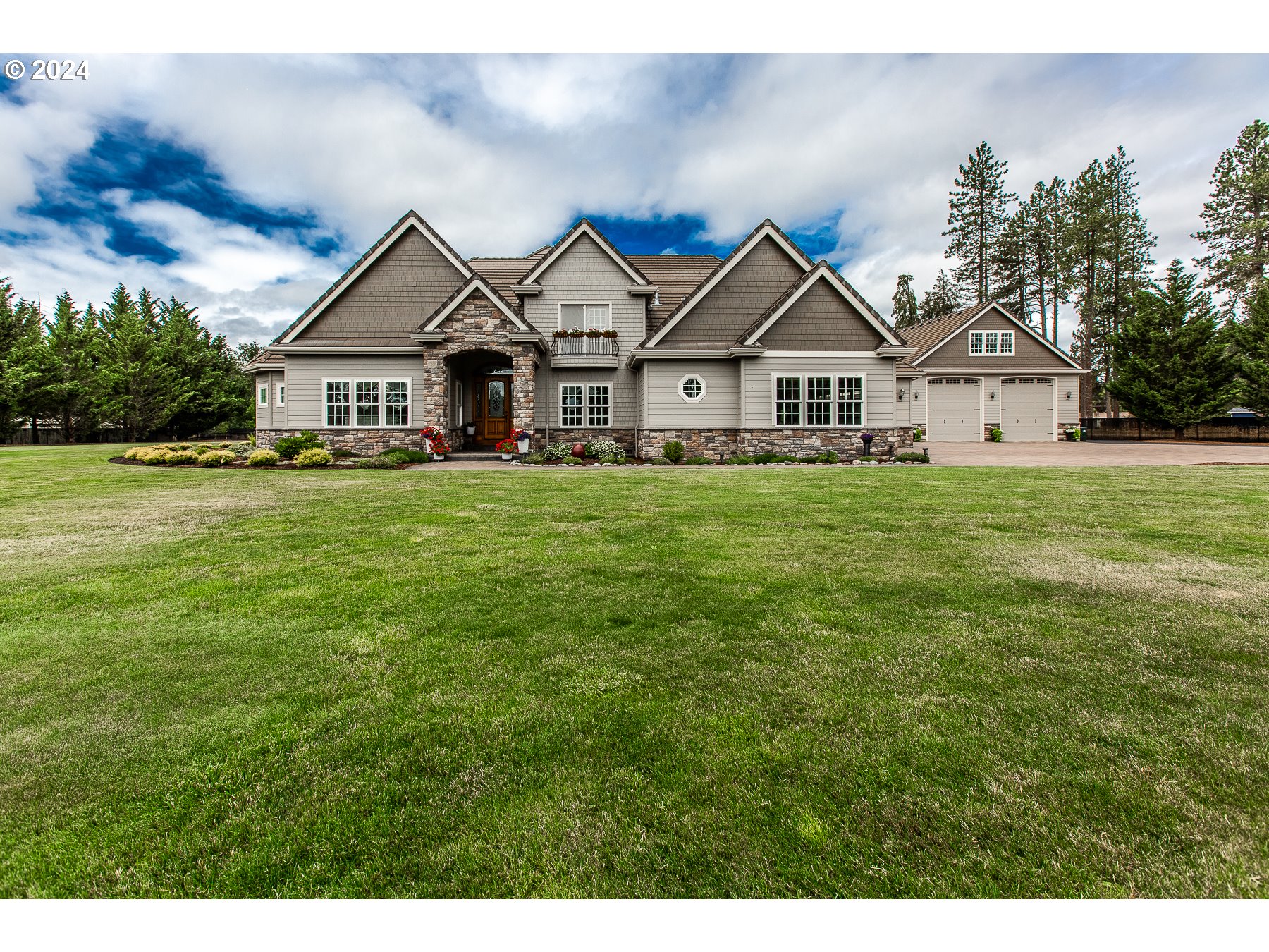 a view of a big house with a big yard and large trees