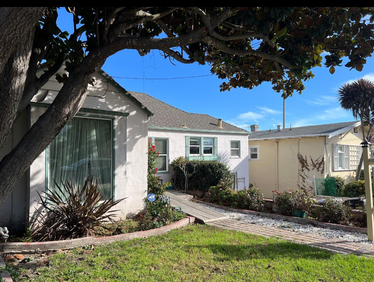 a front view of a house with a yard and potted plants